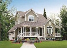 a large green house with white trim and porches