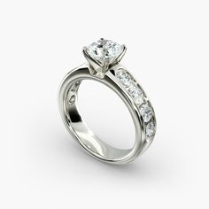 a white gold engagement ring with three stones on the side and channeled band, set in