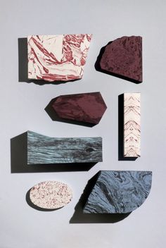 several different shapes and sizes of rocks on a white surface