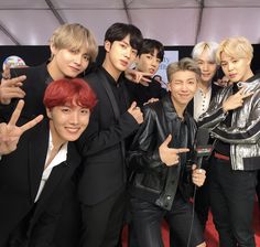 the group of young men are posing together for a photo in front of a red carpet