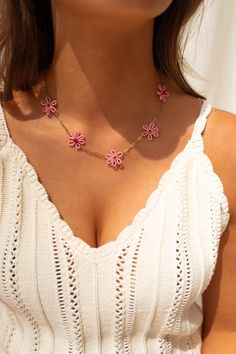 Fun and playful, this necklace features a variety of stylish beaded pink flowers on a shiny golden finish chain. Made with durable stainless steel, it is also adjustable for the perfect fit. Pink Adjustable Flower Shaped Necklace, Adjustable Pink Flower-shaped Necklace, Feminine Pink Necklace With Adjustable Chain, Pink Flower Pendant Necklace With Clavicle Chain, Pink Flower Pendant Clavicle Necklace, Trendy Pink Flower Jewelry, Pink Choker Necklace For Summer, Handmade Pink Flower-shaped Necklace, Pink Beaded Necklace With Flower Pendant