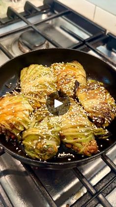 an iron skillet filled with cooked artichokes on top of a stove