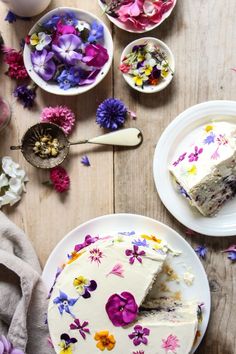 a piece of cake sitting on top of a white plate next to bowls of flowers