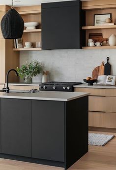 a modern kitchen with black cabinets and white counter tops, an island in the middle