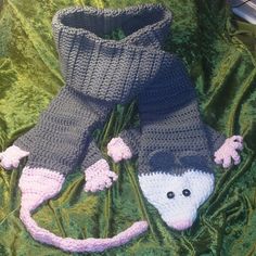 a pair of knitted slippers with a mouse on them laying in the grass