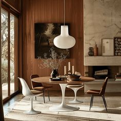 a dining room table and chairs in front of a window with wood paneled walls