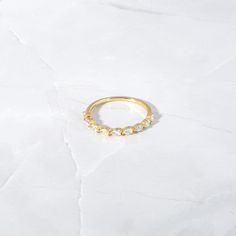 a gold ring with five small pearls on the side and one smaller bead at the top