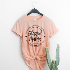 a t - shirt that says, blessed mama on it next to a cactus