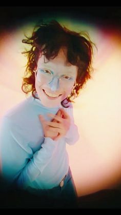 a woman with glasses is smiling and posing for the camera while wearing a white shirt