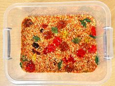 a plastic container filled with food on top of a wooden table