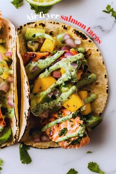 two fish tacos with avocado, mango salsa and cilantro