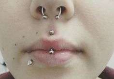 a woman with three piercings on her nose