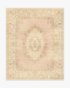 a beige rug with an ornate design on the center and sides, in various colors