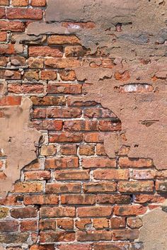 an old brick wall with peeling paint and chipping off the top part is shown