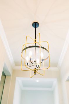 a chandelier hanging from the ceiling in a room with white walls and ceilings