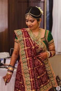 a woman in a red and green sari is getting ready to walk down the aisle