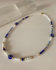 a blue and white beaded necklace on a table