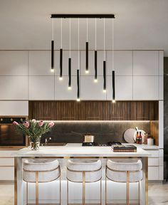 a kitchen with an island and bar stools in front of the countertop area