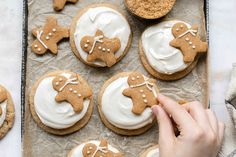 a person decorating cookies with icing on a baking sheet