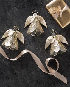 three pieces of gold jewelry sitting on top of a table next to a gift box