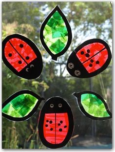 four little ladybugs made out of stained glass sitting on top of a window sill