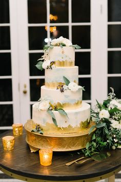 a white and gold wedding cake on a table