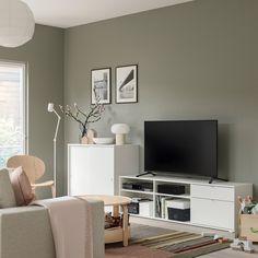 a living room filled with furniture and a flat screen tv on top of a wooden stand