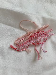 a close up of a piece of fabric on a white cloth with red and pink thread