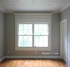 an empty room with hard wood floors and white trim on the windowsill, painted in light gray