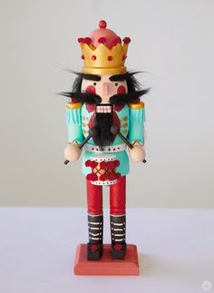 a wooden nutcracker with a crown on it's head and long black hair