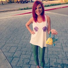 a girl with red hair and green leggings is standing on a skateboard