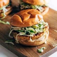 two chicken burgers on a wooden cutting board