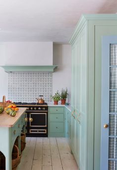 a kitchen with green cabinets and wooden floors