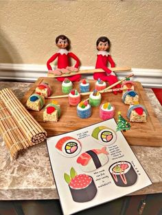 two dolls are sitting on a table with sushi