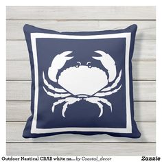 a blue and white crab pillow sitting on top of a wooden floor