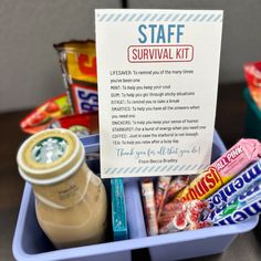 a blue container filled with lots of different types of snacks and drinks next to a sign that says staff survival kit