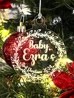 a baby's first christmas ornament hanging from a christmas tree