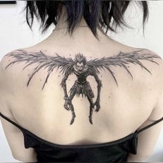 the back of a woman's shoulder with an image of a demon on it