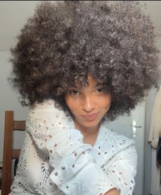 a woman with an afro is posing for the camera