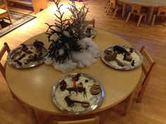 the table is set with four plates that have food on them, and there are flowers in the center