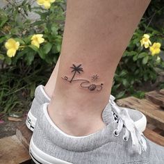 a small palm tree tattoo on the ankle