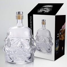 a glass bottle with a skull on it next to a box