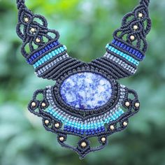 Create a statement with this standout bohemian necklace designed by Thailand's Kanjana. The artisan hand knots blue black and grey polyester cords around a large mottled sodalite stone using macrame techniques while petite brass beads adding shining accents. A sliding knot closure lets you adjust the necklace to the length of your liking.