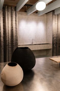 two black and white vases sitting on top of a metal table next to a sink