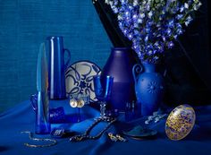 blue vases and other decorative items sit on a blue tablecloth with gold accents