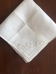 This is such a beautiful vintage hanky.  Fine Linen, French embroidery and hemstitched edges.  One of a kind special hanky. Like New! It is pure white, and measures 12 inches square (6 X 6 when folded).  Excellent vintage condition with no marks, holes or signs of wear. Free Shipping in the US! Please note this is a small item and will be sent in a regular envelope. Vintage Handkerchief, Traditional White Handmade Handkerchiefs, Classic White Lace Handkerchiefs, Classic White Lace Handkerchief, Embroidered Hankies, Bridal Handkerchief, Vintage White Floral Print Handkerchiefs, Vintage White Rectangular Handkerchiefs, Embroidered Handkerchief Wedding