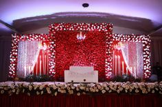 the stage is decorated with red and white flowers