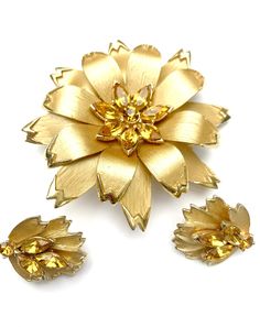 Serendipity treasures present this Mid centuryflower leaf Brooch and matching Earring set. It consists of a brushed gold tone metal with orange glass rhinestones in a flower design The brooch is 2 3/4 inches x 2 7/8 inches. the earrings are clip on earrings. they are 1 x 1 inches in diameter. this mid century floral jewelry set is unsigned They are in good vintage condition with some minor wear to the clips. Thank you very much for stopping by . Please feel free to email (CONVO) me with any ques Mid Century Floral, Queens Jewels, Fused Glass Necklace, Trifari Brooch, Floral Pins, Coral Bracelet, Crystal Bangle, Earrings Women, Gold Orange