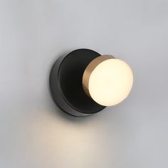 a light that is on the side of a wall with a white ball in it