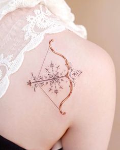 a woman with a bow and arrow tattoo on her back